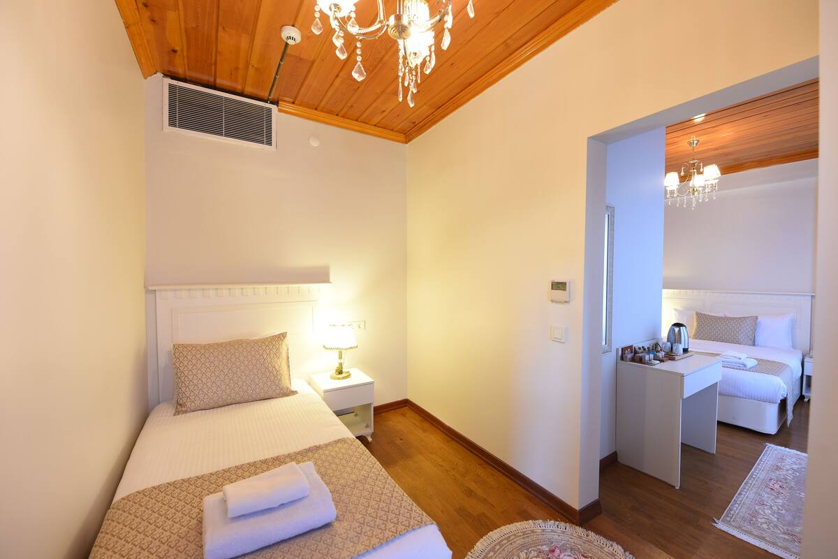Une chambre à coucher avec un grand lit, une table de chevet, une lampe et un petit bureau avec une chaise.