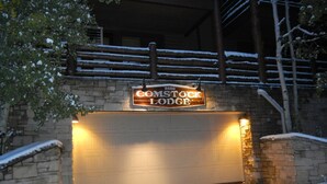A snow-covered entrance to a lodge with a sign reading "COMSTOCK LODGE".