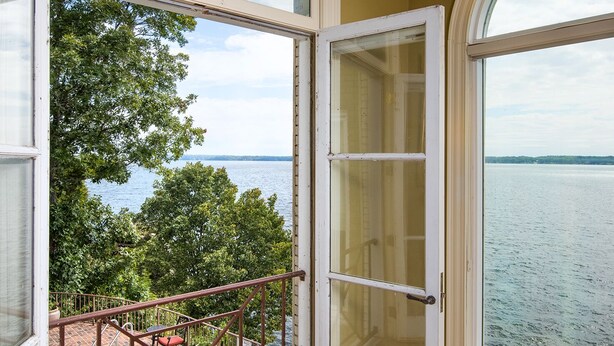 A room with a large window overlooking a swimming pool and a body of water. - The Retreat with  Wilson Dam view & Water Aces (Florence)