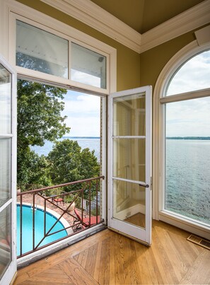 A room with a large window overlooking a swimming pool and a body of water. - The Retreat with  Wilson Dam view & Water Aces (Florence)