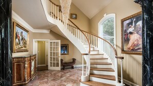 A grand staircase with white balustrades, marble flooring, and classical paintings. - The Retreat with  Wilson Dam view & Water Aces (Florence)