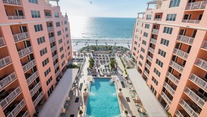 Un hotel de gran altura con piscina central, balcones y vistas a la playa.