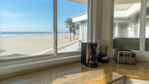 Una cocina con vistas a la playa, cafetera y tostadora.