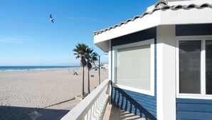 Un edificio frente a la playa con un balcón con vista al mar.