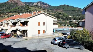 A building with a sloped roof and a small balcony. - Appartamento Portolongone (Porto Azzurro)
