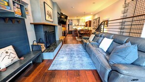 A modern living room with a fireplace, leather sofa, and a dining area. - Luxury Condo w/ FREE WiFi, Parking, Heated Pool, Hot Tubs, Skier Shuttles (Avon)