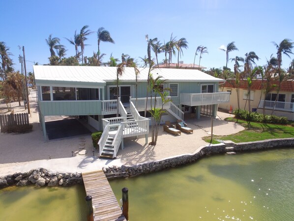 A beachfront property with a two-story building, a dock, and a small pool.