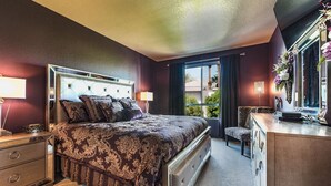 Una camera da letto con un letto grande, comodini, una cassettiera e una finestra vista verde.