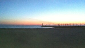 Ein Strand mit einem Steg, der sich ins Wasser erstreckt.