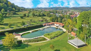 A large pond with a bridge, surrounded by green fields and houses. - Gasthof Zur Post (Königstein)