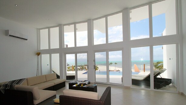 A spacious living room with a large window overlooking a beach.