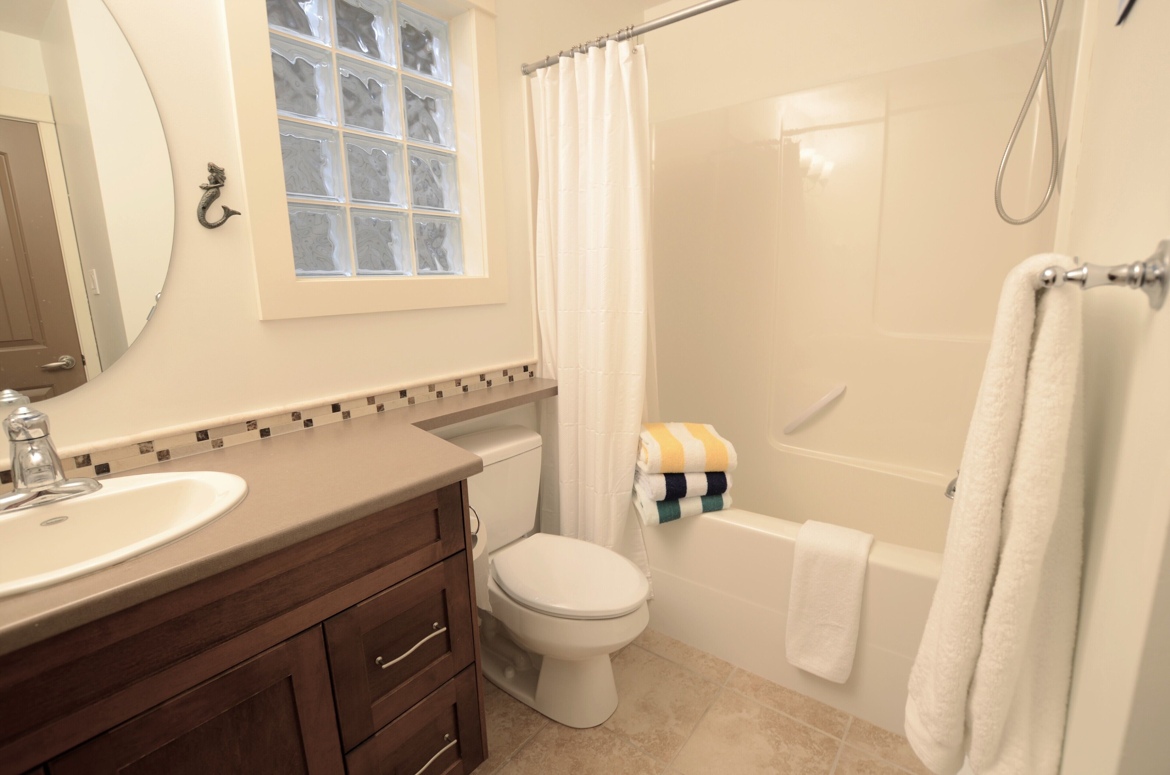 Ein Badezimmer mit Waschbecken, Toilette, Badewanne und Duschvorhang.