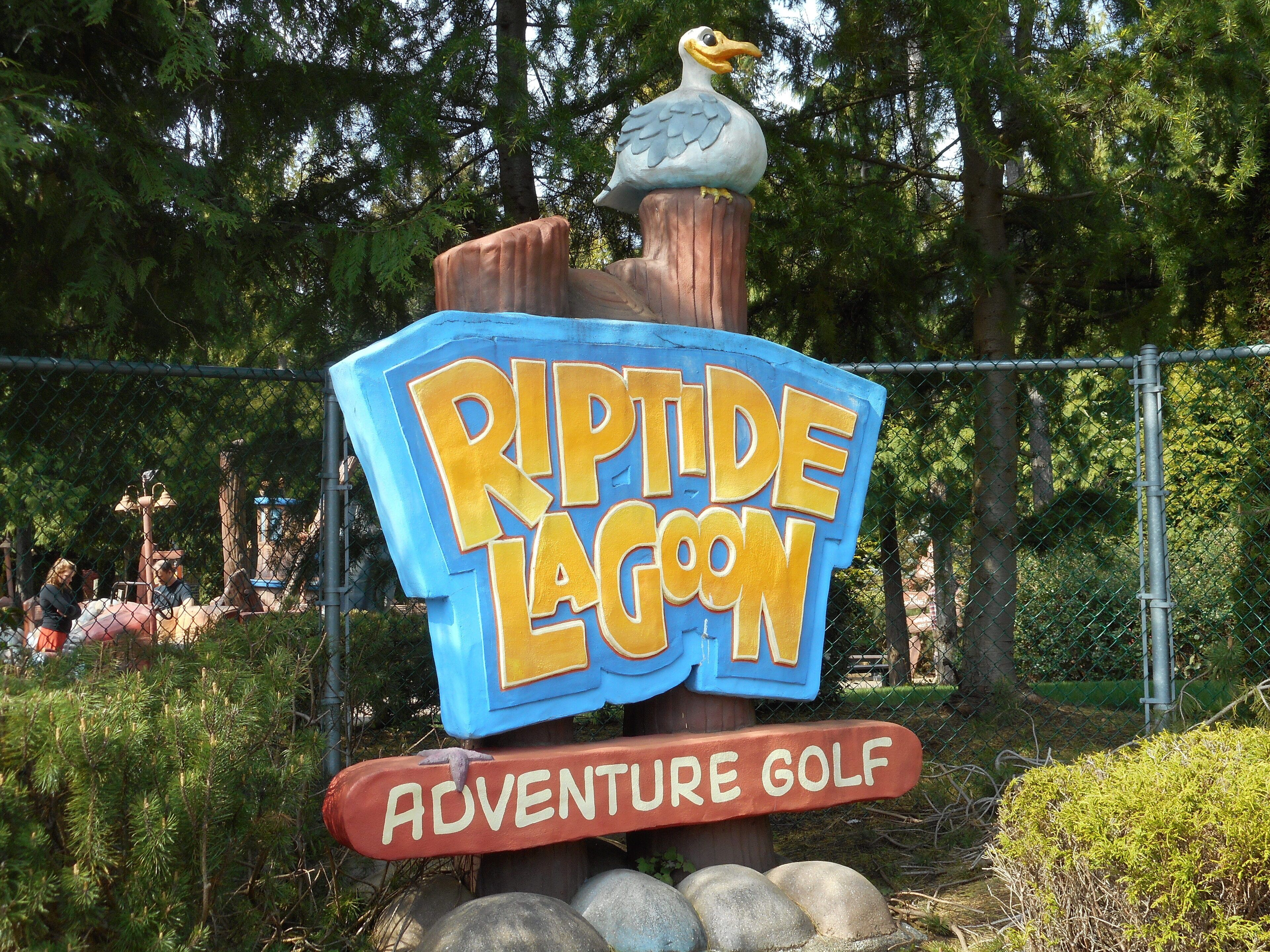 Ein Schild für 'Riptide Lagoon Adventure Golf' mit einer Vogel-Skulptur obenauf.