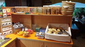 A breakfast buffet setup with various food items and condiments. - Verwöhn-Pension Wiesengrund (Bischofsgruen)