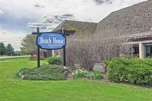 Une enseigne indiquant « Restaurant Beach House », avec un bâtiment de style traditionnel en arrière-plan.