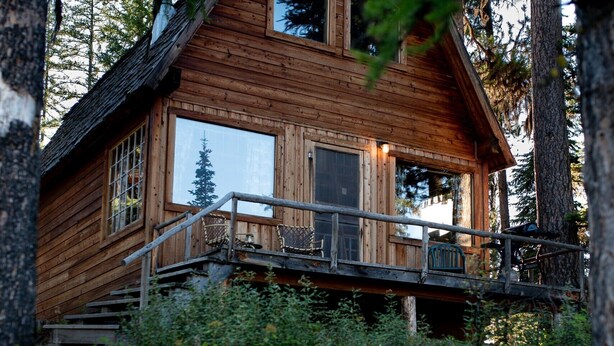 A wooden cabin with a balcony, surrounded by dense forest. - "Elk's Run"  Rustic Cabin Hidden Among The Pines At Falls Creek. (Condon)