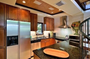 Enjoy cooking in this well-equipped kitchen with a refrigerator, dishwasher, and range hood.