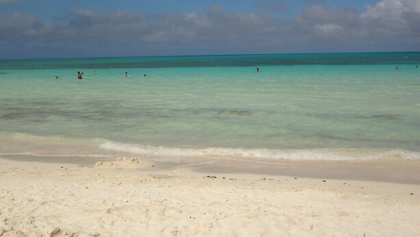 A beach with clear turquoise water and a sandy shore. - Amazing Tao loft overlooking the golf course. (Akumal)