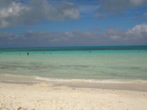 Ein Strand mit klarem türkisblauem Wasser und einem sandigen Ufer.