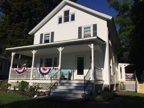 Enjoy the charm of this two-story house with a welcoming front porch and central chimney.