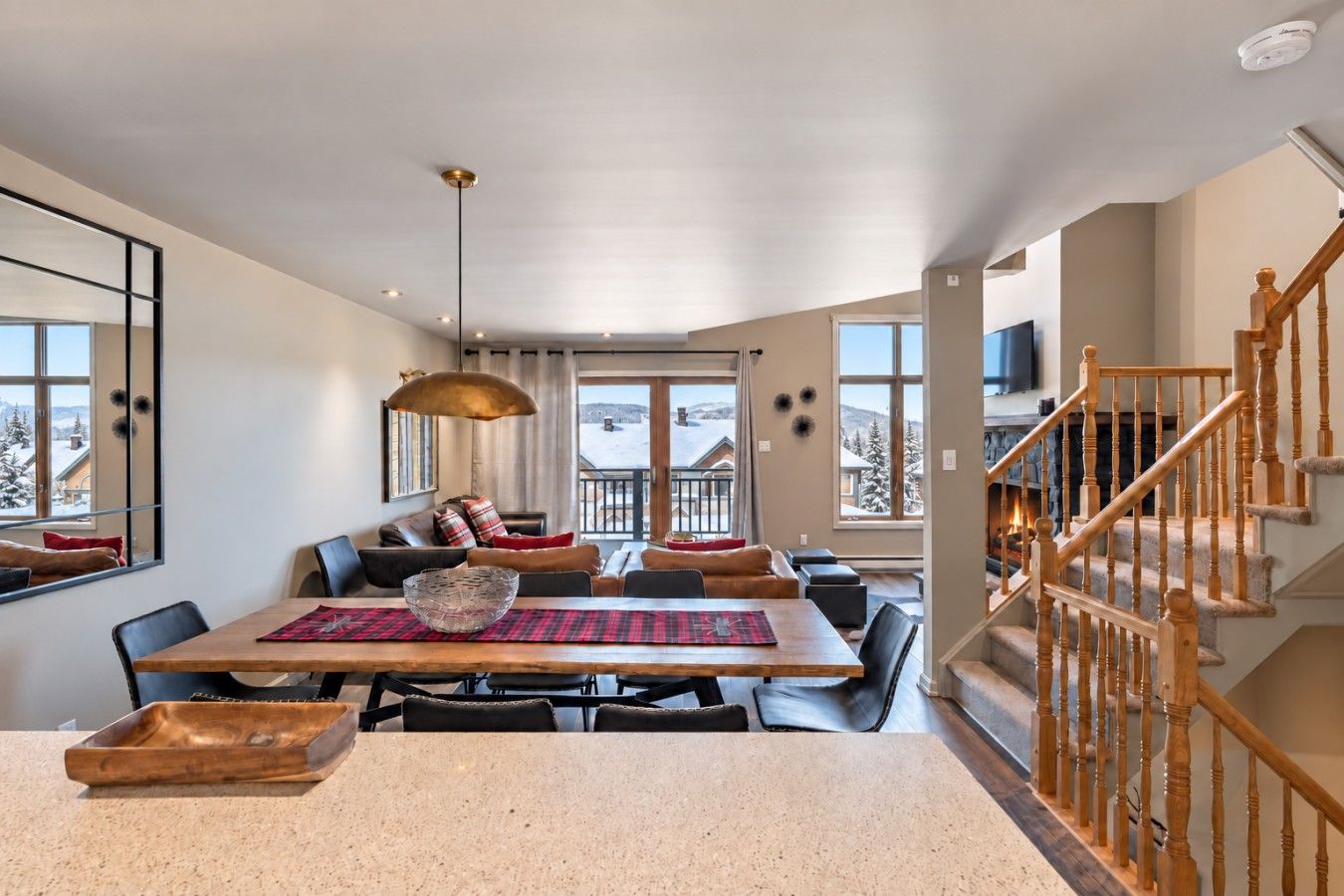 A spacious dining area with a large table, comfortable seating, and a view of the snowy landscape through the windows.
