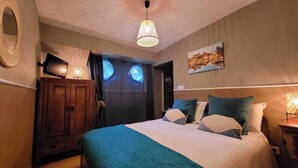 A bedroom with a bed, a wooden wardrobe, a desk with a lamp, and a painting on the wall. - Péniche Amboise Maison d'hôtes Toulouse (Toulouse)