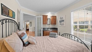 Une chambre avec un lit, une salle de bain avec un lavabo et une cuisine avec des placards.