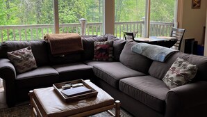 A living room with a large window, a sofa, a coffee table, and a rug. - Stowe 2 BR / 2 BA Vacation Condo off Mountain Road (Stowe)