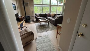 A cozy living room with a sofa, coffee table, and a fireplace. - Stowe 2 BR / 2 BA Vacation Condo off Mountain Road (Stowe)