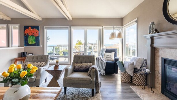 Un salón amplio con chimenea, ventanas grandes y vistas a la ciudad.