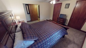 A bedroom with a bed, dresser, and a television. - Pines Lodge at Sand Run Lake in WNF, Hocking Hills (Nelsonville)