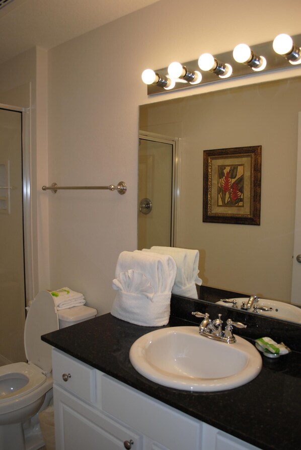 A bathroom with a sink, mirror, and towel rack. - Ground Floor 1FL - Beachfront - Self Check-in/Out - Optional beach services (Panama City Beach)