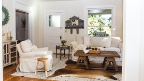 A cozy living room with a white sofa, a wooden coffee table, and a cowhide rug. - Beautiful Chico Farmhouse With Room for All…10 beds!! (Chico)