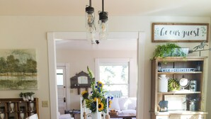 A dining area with a rustic wooden table, white chairs, and a chandelier. - Beautiful Chico Farmhouse With Room for All…10 beds!! (Chico)