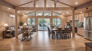 A spacious kitchen with wooden cabinets, a dining area with a table and chairs, and a large window providing natural light.
