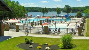 A pool area with multiple pools, umbrellas, and lounge chairs.