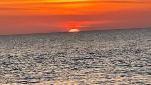 A sunset over a calm sea with a horizon line. - Beautiful Beach House with large pool (Boca Grande)