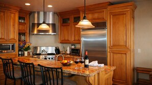 A kitchen with wooden cabinets, stainless steel appliances, and a granite countertop.