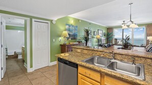 A kitchen with granite countertops, a dishwasher, and a double sink. - Ariel Dunes #2107 2BR/2BA - Gorgeous Gulf Views (Miramar Beach)
