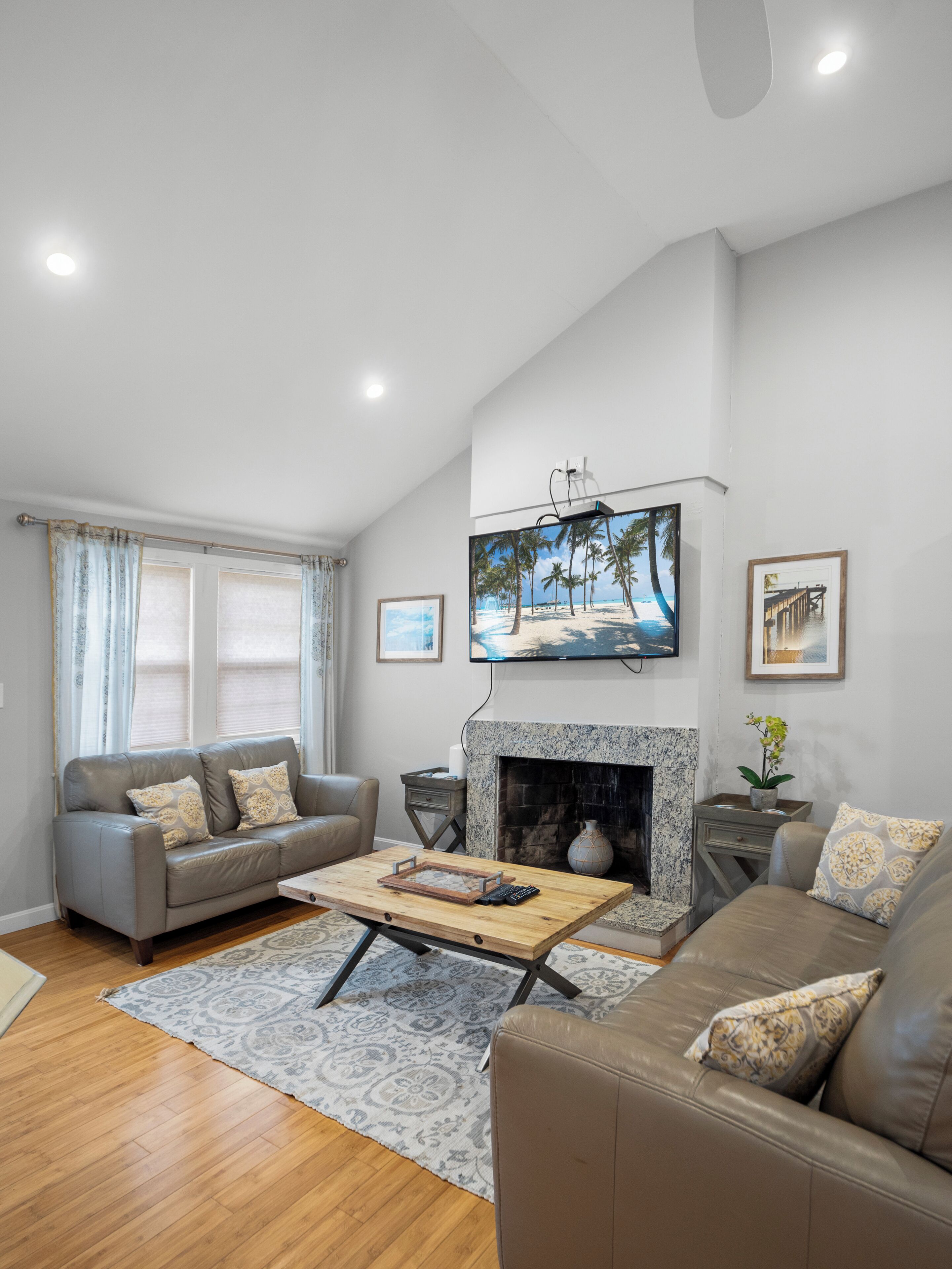 A living room with a fireplace, a television mounted on the wall, and a sofa.