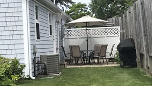 A backyard with a patio, outdoor furniture, a grill, and a white fence. - Brand New Luxurious Town Home, 600 Feet To Englewood Beach (Yarmouth)
