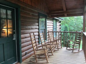 Sit on the porch and enjoy the serene surroundings from the comfort of this cozy cabin.
