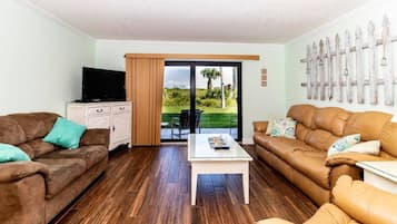 A living room with two sofas, a coffee table, and a TV on a cabinet.