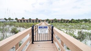 A wooden boardwalk leading to a gated area with a sign prohibiting trespassing for boardwalk use by only residents and guests. - Ponce Landing 7 (Saint Augustine)