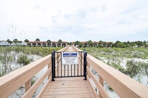 A wooden boardwalk leading to a gated area with a sign prohibiting trespassing for boardwalk use by only residents and guests. - Ponce Landing 7 (Saint Augustine)