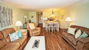 A living room with two sofas, a coffee table, and a dining area with a table and chairs. - Ponce Landing 7 (Saint Augustine)