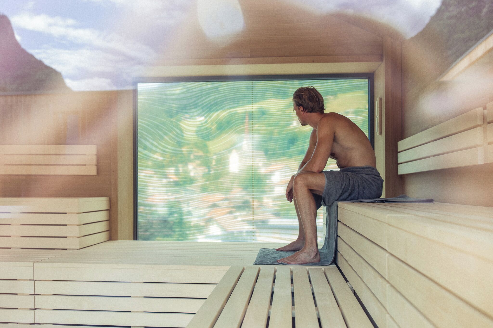Eine Sauna mit Holzbänken und einem großen Fenster.