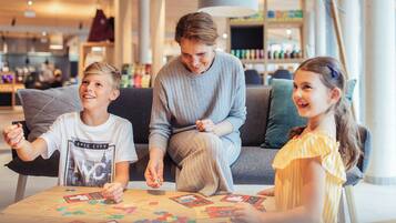 A family seated at a table with educational materials, in a modern indoor setting with a visible store in the background.
