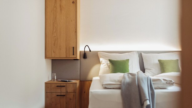 Une chambre à coucher avec un lit, une table de chevet et une armoire en bois.