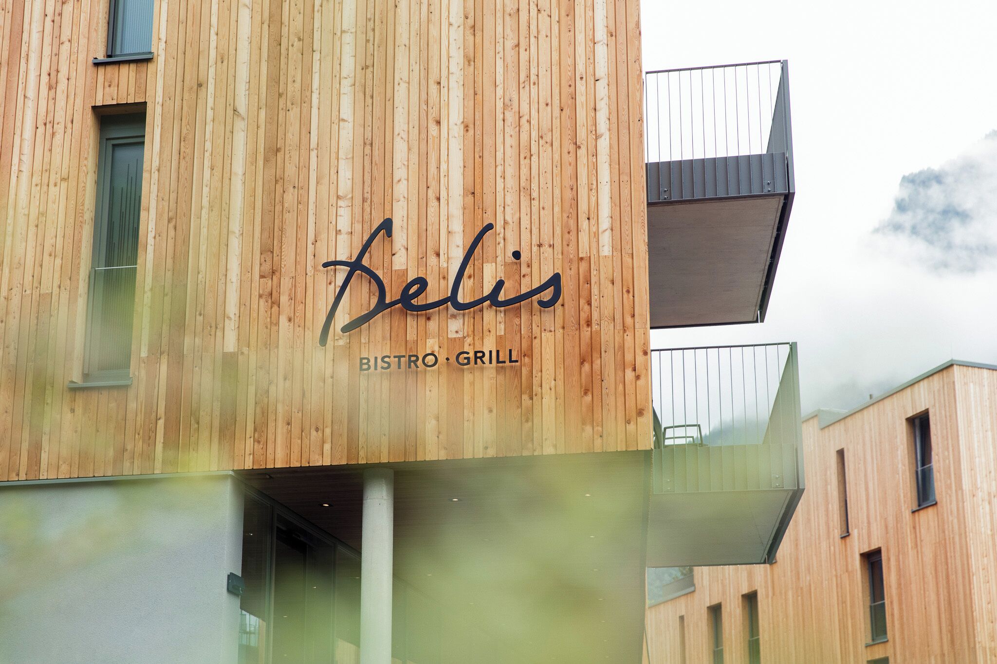 A wooden exterior of a building with the name 'Belis' and 'BISTRO GRILL' indicating a dining establishment.
